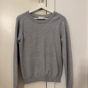 Grå stickad tröja från Vila - Säljer en grå stickad tröja från Vila. Tröjan är använd ett fåå tal gånger och är inte nopprig. 