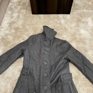 Grå kappa från Havana - Grå Havana kappa med krage och bälte. Kappan har knappar framtill och ett innerfoder.  Skick: 9/10. Varan har inga eller små tecken på användning Storlek: L Färg: grå Ord. Pris: 499  Din stil: spara inlägget så du inte missar denna kappa Inte din stil: Kolla min profil. Du kommer hitta något för alla kön och åldrar.