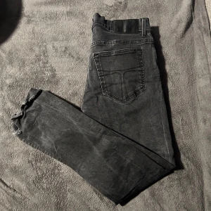 Svarta jeansbyxor från tiger of Sweden  - Snygga svarta jeansbyxor från tiger of Sweden med en klassisk femficksdesign. Byxorna har en knapp och dragkedja framtill. Perfekta för en stilren look.