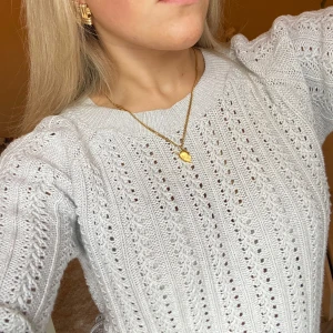 Grå stickad tröja - Säljer en stilren grå stickad tröja med ett vackert hålmönster. Tröjan ribbade muddar vid ärmslut och nederkant. Den är i storlek XS men passar mig som är S superbra! Knappt använd  och en gammal modell från lager 157. Perfekt nu till våren och alla sommarkvällar! 