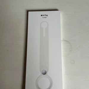 Vit AirTag Loop - Säljer en vit AirTag Loop från Apple. Perfekt för att fästa din AirTag på väskor eller andra tillhörigheter. Enkel och stilren design som håller din AirTag säker och lättillgänglig.