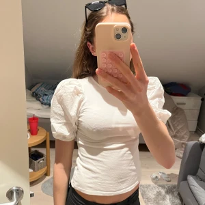 Vit blus med puffärmar - Säljer en söt vit blus med puffiga korta ärmar. Perfekt för en stilren och chic look. Blusen är gjord i ett mjukt material som känns skönt mot huden. Passar bra till både jeans och kjol. Hör av dig vid intresse!