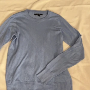 Ljusblå tröja från Amisu - Säljer en ljusblå tröja från Amisu med rund hals och långa ärmar. Perfekt för en stilren look. Tröjan är tillverkad i ett mjukt material som känns skönt mot huden. Passar bra till både jeans och kjol.