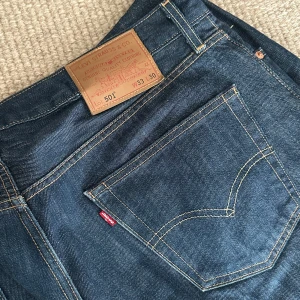 Levis 501 jeans - Klassiska Levis 501 jeans i en snygg mörkblå denim. De har en rak passform och är tillverkade i slitstarkt jeansmaterial. Perfekta för en tidlös stil.