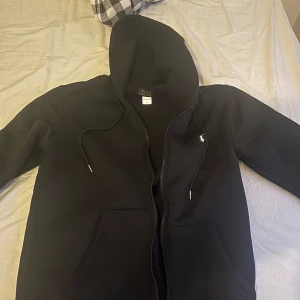  Ralph Lauren. Svart zip hoodie - Säljer en stilren svart hoodie från Ralph Lauren. 10/10 skick. Lätt viktig. Köpt i butik. Pris kan diskuteras vid snabb affär😁