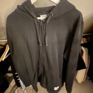 Svart hoodie från Frank Dandy - Säljer en svart hoodie från Frank Dandy. Den har en dragkedja framtill och en klassisk huva.