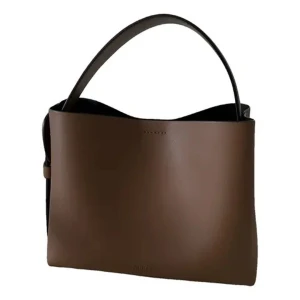 Väska från ARKET - Snygg brun axelväska i skinn med stilren design. Väskan har ett brett handtag och en avtagbar axelrem. Insidan är rymlig med en dragkedja för säker förvaring. Perfekt för att bära dina dagliga nödvändigheter med stil. Den är i mycket bra skick😍(använd 2 gånger)