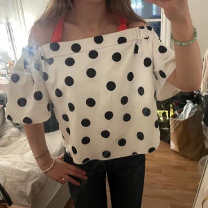 Vit offshoulder topp med svarta prickar - Säljer en söt vit offshoulder topp med stora svarta prickar. Storleken är L men skulle säga sitta mer som M