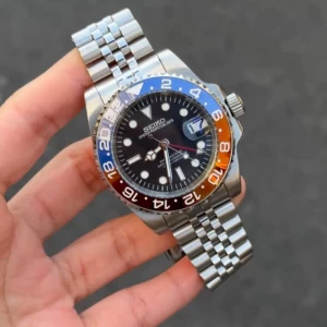 Seiko ”Pepsi” GMT Mod - Seiko Mod GMT är inspirerad av den ikoniska GMT-designen och drivs av Seiko NH34 automatisk rörelse. En 40 mm klocka som kombinerar elegans och funktionalitet.  Funktioner: • Diameter: 40 mm • Rörelse: Seiko NH34 automatisk • Tjocklek: 12 mm • Glas: Safir, rep-resistent • Luminova: Ja • Material: 316L rostfritt stål • Bezel: Keramik • Armband: 316L stål med säkerhetslås • Vattentålig: 3 ATM • GMT-funktion: Ja