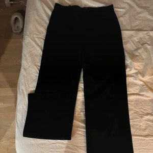 Svarta kostymbyxor - Snygga svarta byxor med hög midja och rak passform från Veromoda. Perfekta för en stilren look. De är tillverkade i ett mjukt material som ger en bekväm känsla hela dagen. Storlek M. Endast använda någon enstaka gång, därav fint skick. Nypris runt 500, mitt pris 200kr därav de fina skicket. 