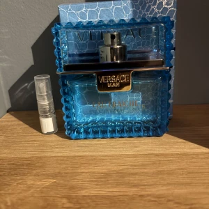 Versace Man Eau Fraîche 2ml - Säljer en fräsch och maskulin parfym från Versace, Eau Fraîche. Flaskan är i en klarblå färg med en elegant design och silverdetaljer. Perfekt för den som vill ha en lätt och uppfriskande doft. 2ml