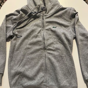 Grå hoodie från Lacoste - En Lacoste zip hoodie helt ny har bara provat den på 