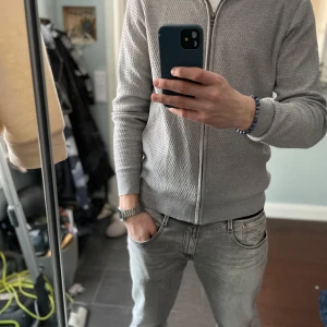 Grå kofta från S.C.W. - Säljer en stilren grå fullzip kofta från S.C.W. Riktigt skön och najs textur som gör den väldigt snygg. Storlek M, hör av er vid intresse🤗