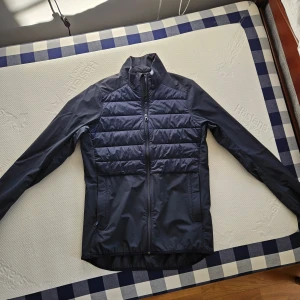 J.LINDEBERG hybridjacka nyskick  - Tjenare, säljer denna J.Lindeberg jacka i perfekt skick.  Det är en klassisk hybridjacka med äkta dun.🕊  Perfekt som vårjacka eller som träningsjacka.☀️  Storlek S relativ slim passform, kan skicka mått om så önskas.