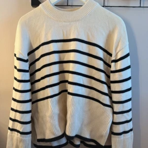 Vit och svart randig tröja - Säljer en snygg vit tröja med svarta ränder. Tröjan har en ribbad rund hals och långa armar. Storlek S och använd fåtal gånger. Från gina tricot.
