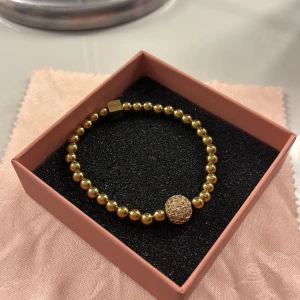 Guldarmband med glittrig detalj - Elegant guldarmband med runda pärlor och en glittrig kula som detalj. Nypris 499 från ioaku ”berry sparkle chain armband”. Använt fåtal gånger❤️