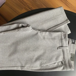 Grå randiga kostymbyxor från Only & Sons - Snygga grå kostymbyxor från Only & Sons med diskreta vita ränder. W29 L32 aldrig använda 