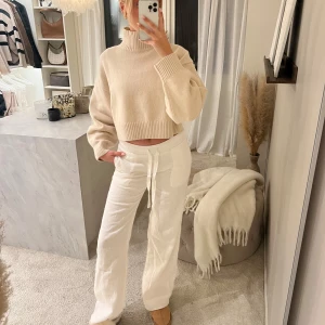 Beige croppad stickad polotröja från H&M  - Säljer en beige croppad stickad polotröja med breda ärmar och ribbade muddar. Tröjan har en hög polokrage och är perfekt för dig som gillar en avslappnad men trendig stil.