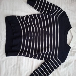 Marinblå randig tröja från Zara - Säljer en marinblå tröja från Zara med vita horisontella ränder. Tröjan har rund halsringning och långa ärmar. Perfekt för en stilren och avslappnad look.💗