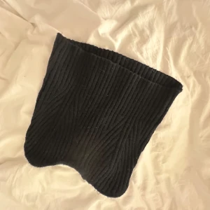 Svart stickad halsvärmare - Säljer en svart stickad topp i mjukt material. Enkel och stilren design som passar till det mesta.