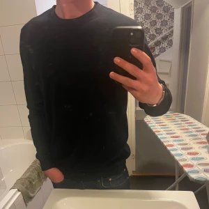 Crewneck från Dressmann - Säljer en stilren mörkblå långärmad tröja från Dressmann i bomull. Tröjan har en klassisk rund halsringning och enkel design som passar till många tillfällen. Perfekt basplagg i garderoben! Inga defekter eller liknande. Helt ny!!
