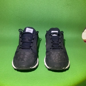  Nike sneakers  - Säljer ett par svarta Nike sneakers med vit sula och silverfärgad swoosh på sidan. Skorna har snörning och är tillverkade i syntetmaterial med mesh-detaljer för extra andningsförmåga. Perfekta för träning eller vardagsstil. Pris kan diskuteras kom gärna med förslag. 