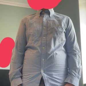 Ljusblå skjorta från Polo Ralph Lauren - Säljer en klassisk ljusblå skjorta från Polo Ralph Lauren i modellen Custom Fit. Skjortan har knappar framtill, button-down krage och lång ärm. Perfekt för en stilren look med diskret broderad logga på bröstet. Ny pris är 1700kr