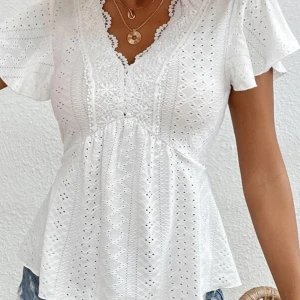 Vit blus med spetsdetaljer och v-ringning - Superfin vit blus med v-ringning och spetsdetaljer. Blusen har korta, luftiga ärmar och ett broderat mönster över hela tyget. Perfekt för vår och sommar!