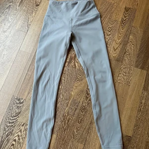 Grå leggings från Lululemon - Snygga grå leggings från Lululemon med hög midja och tight passform. Perfekta för träning eller en aktiv vardag. Mjukt och stretchigt material som sitter skönt mot kroppen. SIZE 4