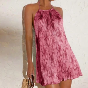 Rosa halterneck klänning med öppen rygg - NYSKICK Säljer en kort rosa klänning med halterneck och öppen rygg. Klänningen har ett lätt mönster och är tillverkad i ett tunt, flowy material. Perfekt för varma dagar och somriga tillfällen.