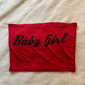 Röd tubtopp med text från shein  - Säljer en röd tubtopp från shein  med svart text 'Baby Girl' framtill. Toppen är ärmlös och har en enkel, tight passform. Perfekt för dig som vill ha en statement-piece i garderoben!