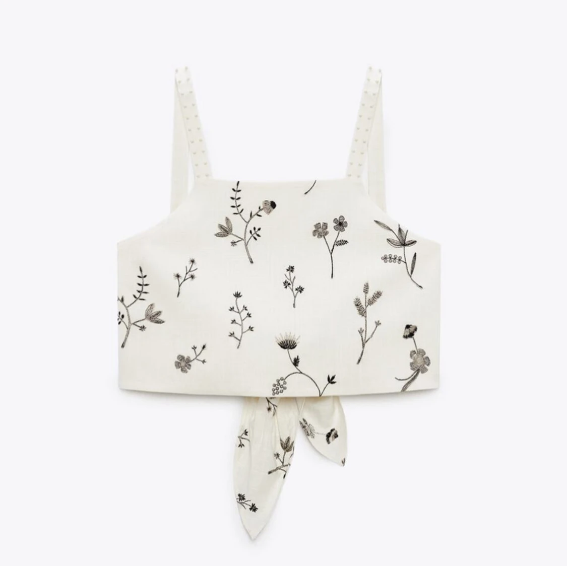 Vit blommig linnetopp med brodyr knyt