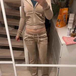 Beiga velourbyxor från Juicy Couture - Säljer/byter ett beigt Juicy Couture set med låg midja och raka ben. Kan tänka mig byta mot annan färg i strl xxs/xs eller sälja setter för 600kr