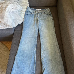 Ljusblå jeansbyxor från Bershka - Säljer ett par ljusblå jeansbyxor från Bershka med klassisk femficksdesign och raka, vida ben. Jeansen har normal passform och stängs med dragkedja och knapp. Perfekta för en avslappnad och trendig look. Aldrig använda, storlek 38!!