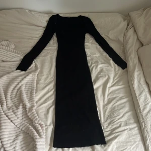 Svart långklänning med fyrkantig ringning - Säljer en svart långklänning med lång ärm och snygg fyrkantig ringning. Klänningen har en tight passform och är perfekt för dig som vill ha en stilren och elegant look. Materialet är stretchigt och följsamt. Jag har vanligtvis storlek M och den passar ändå utmärkt då tycker är väldigt stretchiga 
