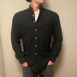 Mörkblå skjorta från Ralph Lauren - Säljer en mörkblå långärmad skjorta från Ralph Lauren i slim fit-modell och storlek Large. skicket är mycket bra 8/10 inga fläckar, skriv om du har frågor!