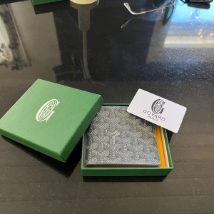 Grå plånbok  - Säljer en exklusiv grå plånbok ett ikoniskt mönster. Plånboken har flera kortfack och är tillverkad i skinn. Perfekt för dig som vill ha en stilren och lyxig accessoar.