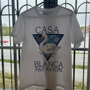 Vit t-shirt med svantryck från Casablanca - Vit t-shirt från Casablanca med stort tryck av en svan och texten 'Casa Blanca Par Avion' på framsidan. Klassisk rund hals och korta ärmar. Perfekt för en avslappnad och stilren look.                   (Helt ny, aldrig använt) säljer för att jag inte gillade den overzize looken