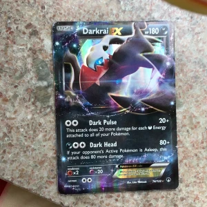 Darkrai EX Pokémonkort - Säljer ett Darkrai EX samlarkort från Pokémon med holografisk yta. Kortet har 180 HP och attacker som Dark Pulse och Dark Head. Kortet är svart med färgglada detaljer och har en cool illustration av Darkrai.