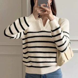 Vit och svart randig stickad tröja - Säljer en ribbstickad tröja i vit med svarta horisontella ränder. Tröjan har v-ringad krage och långa ärmar, perfekt för dig som gillar en chill och klassisk look. Materialet är mjukt och stickat, vilket gör den skön att bära under kyliga dagar.