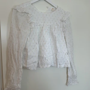 Vit blus med guldiga detaljer  - En fin vit blus med guldiga detaljer, perfekt för middagar. 