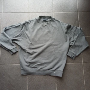 Baggy grå sweatshirt storlek S - Säljer en enkel och stilren grå sweatshirt från ASOS DESIGN i storlek S. Tröjan har rund hals, ribbade muddar vid ärmslut och nederkant, samt långärmad passform. Perfekt för chill dagar och passar till allt.