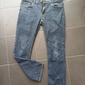 Blå jeans från Hampton Republic - Snygga blå jeans från Hampton Republic med regular fit och klassisk femficksdesign. Jeansen har kontrastsömmar i gult och rak passform som ger en clean och tidlös look. Perfekta för dig som gillar enkel stil och vill ha ett par jeans som funkar till allt.