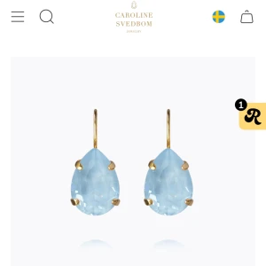 Blå droppformade örhängen Caroline Svedbom - Supersnygga örhängen från Caroline Svedbom med droppformade ljusblå kristaller och guldfärgade detaljer.  Helt nya! Säljer för jag hellre vill ha en annan modell, och försent att lämna tillbaks aldrig använda bara testade 