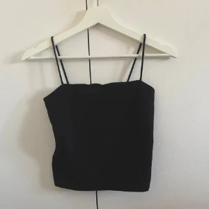 Linne från Gina Tricot - Säljer ett svart linne från Gina Tricot i storlek xs. Linnet är helt nytt med lappen kvar. Modellen heter ”Scarlet singlet”. Linnet har smala axelband och extra tyg vid bysten och är lite kortare i modellen. Säljer ett likadant linne i xs i en annan annons! Köparen betalar frakten! 