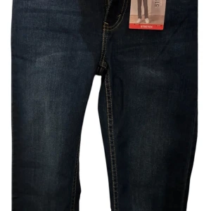Levi's 511 mörkblå slim jeans pojkar - Snygga Levi's 511 jeans i mörkblå tvätt med kontrasterande gula sömmar. Slim fit-modell med stretch för extra komfort och klassiska fem fickor. Perfekt passform från höft till vrist och ikonisk Levi's patch bak. Ett måste för dig som gillar stilrena jeans.