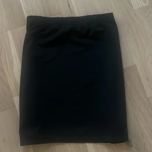 Svart kortkjol från SHEIN XS - En stilren svart kortkjol från SHEIN i storlek XS Petite. Kjolen har en enkel, rak form med resår i midjan för skön passform. Perfekt att matcha med en crop top eller hoodie. Materialet känns lätt och smidigt, vilket gör den enkel att bära.