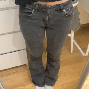Grå bootcut jeans - Snygga grå jeans med bootcut passform och klassisk femficksdesign. Jeansen har en mörkgrå ton och sitter skönt över höfterna med normal midja. 
