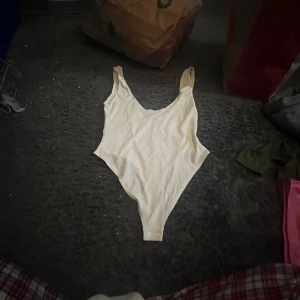 Ribbad vit body med hög skurna ben  - Säljer en snygg vit body, då den ej har använts av mig