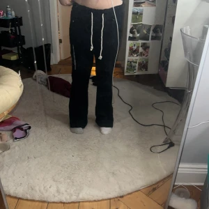 Svarta mjukisbyxor med snörning - Säljer ett par svarta linnebyxor med vita snören i midjan. Byxorna har bootcut-ben och sitter skönt med loose passform. . 